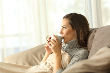 Wall Mural - Woman relaxing at home drinking coffee