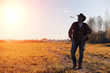 © alexkich - A man cowboy hat and a loso in the field. American farmer in a f