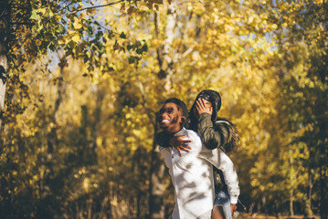 Wall Mural - Young african couple have fun in the autumn forest.