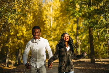 Wall Mural - Young african couple have fun in the autumn forest.