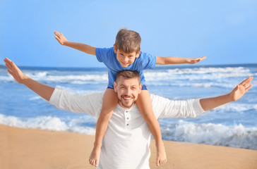 Canvas Print - Cute little boy with father on sea beach at resort