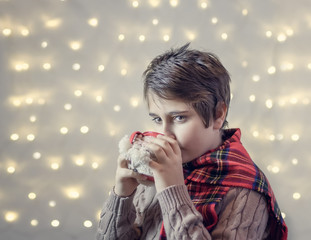 Schoolboy drinks hot chocolate from a cup