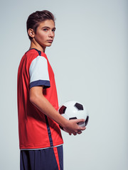 Wall Mural - Photo of teen boy in sportswear holding soccer ball