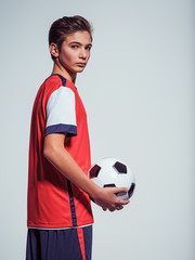 Wall Mural - Photo of teen boy in sportswear holding soccer ball