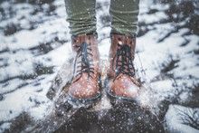 Girl Standing On A Tree Stump In Nature With Falling Snow.