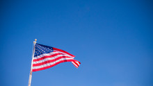 USA American Flag Waving With Clear Blue Sky Background In Horizontal View