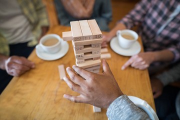 Wall Mural - Senior friends playing jenga game on table in bar