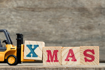 Canvas Print - Yellow plastic forklift hold letter X to complete word XMAS (Christmas) on wood background