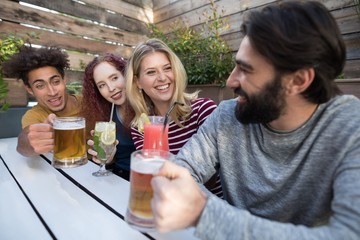 Wall Mural - Friends interacting while having glass of drinks