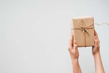 Woman holding wrapped New Year or Christmas present on white background. Happy holidays and celebration concept