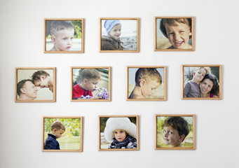 White wall with photos of the family in photo frames. Kid room concept.