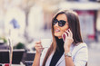 © Jovica Varga - Young attractive business woman talking on the phone and drinking coffee