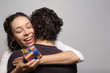 © Vergani Fotografia - Young woman receives Christmas present. Happy girlfriend hugs her boyfriend..