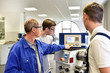 © industrieblick - Berufsausbildung im Handwerk - Jugendliche Azubis und Meister an einer CNC Drehmaschine // Vocational training in the skilled trades - young trainees and master craftsmen on a CNC lathe machine