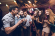 © VadimGuzhva - Young people have fun in a nightclub. Three men and three women staged a musical battle.