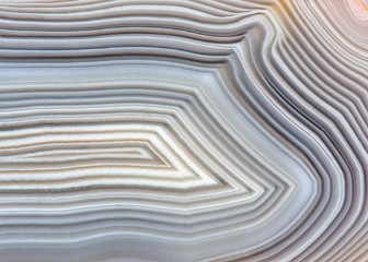 Wall Mural - Amazing Banded Agate Crystal cross section as a background. Natural light translucent agate crystal surface, Gray abstract expressive structure slice mineral stone macro closeup