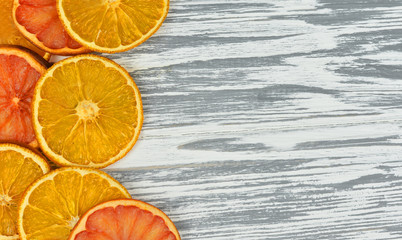 pieces of orange and grapefruit on a white wooden texture on holiday