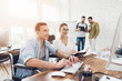 © VadimGuzhva - A man in a wheelchair is showing something on computer to his colleague.