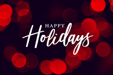 Wall Mural - happy holidays calligraphy with red duotone bokeh lights background