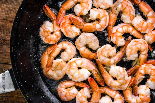 Cuadros en Lienzo Fried shrimp with garlic on pan, preparing dish with seafood, mediterranean cuis
