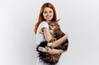 © SHOTPRIME STUDIO - Beautiful young woman on a light background holds a cat