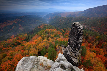 Wall Mural - Rocky landscape during autumn. Beautiful landscape with stone, forest and fog. Sunset in Czech national park Ceske Svycarsko. Misty evening autumn nature. Landscape with rock hills. Dark clouds.