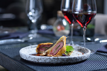 Grilled steak meat with potato gratin and glass of red wine