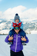 © Matvii - Dad holds his son on his shoulders in the mountains in a ski resort