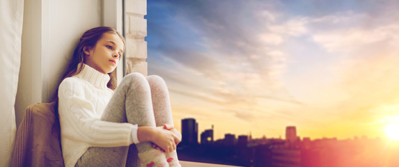 Poster - sad girl sitting on sill at home window