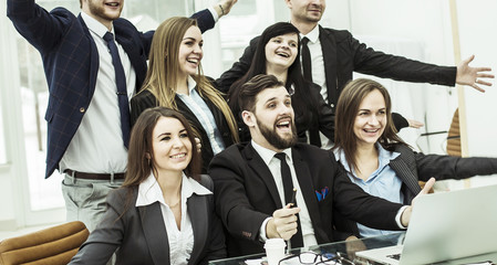 concept of business success - cheering business team in the workplace in the office