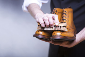 the process of cleaning shoes. a man is cleaning his shoes.