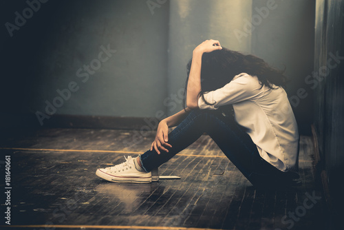 Cuadros en Lienzo Lonely sad woman cry and hug her knees sitting in the dark corner ,Sad woman Unh
