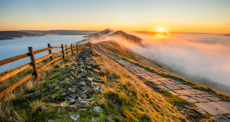 Thick cloud inversion with morning sun casting golden light on the landscape. Taken at Mam Tor in the English Peak District.