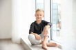 © Africa Studio - Cute little boy sitting near window at home