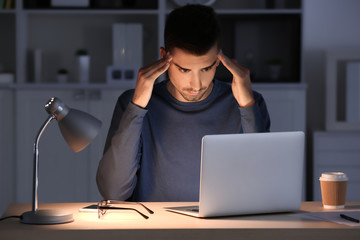 Canvas Print - Tired man with laptop in office