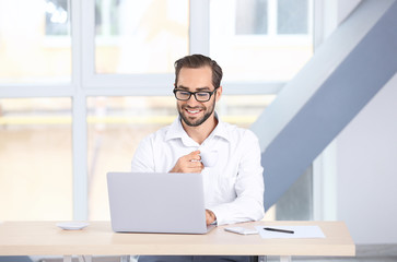 Wall Mural - Attractive man with laptop at home