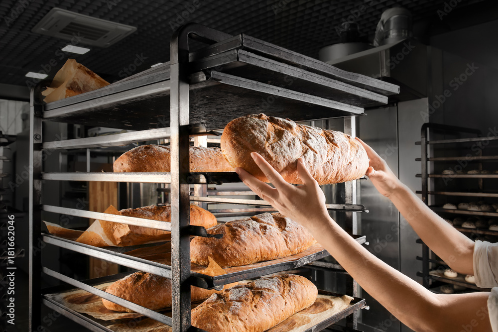 Woman holding fresh bread in bakery
