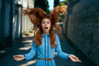 © SHOTPRIME STUDIO - Beautiful young woman in a blue dress walking along the boulevard in the city