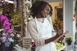 © Wavebreak Media - Female florist noting order in dairy while talking on mobile