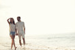 © FS-Stock - Happy fun beach vacations couple walking together laughing having fun on travel destination.