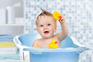 baby kid taking bath, looking upwards and playing