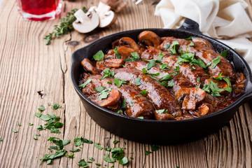 Wall Mural - Sausages with onion and mushrooms gravy