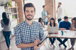 © deagreez - All for one and one for all! Leadership. Successful stylish young bearded man in casual checkered shirt is standing in the office, smiling, making notes