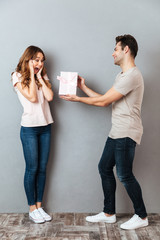 Sticker - Full length portrait of a man giving a present box