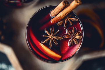 Christmas hot mulled wine in a glass with spices and citrus fruit. Mulled wine with cinnamon, anise and orange. 