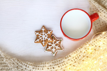 Wall Mural - drink for winter vacation/ cup with milk and figured gingerbread cookies next to warm blanket and lights top view