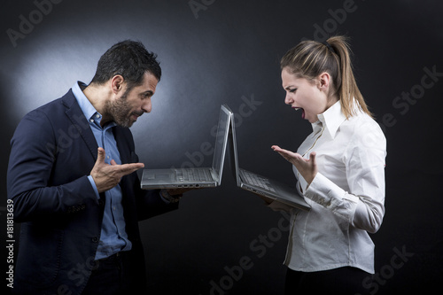 Foto un uomo al computer scrive ad una ragazza che legge divertita (non si guardano a