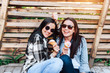 © bedya - Two pretty brunette girls eating ice cream outdoor