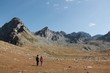 © OZKAN - adventurer back packer young couple hiking a mountain and walking towards the glacier lake in summer