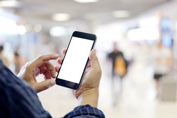 Man using smartphone in shopping mall space background and copy space. Blank screen for graphics display montage.